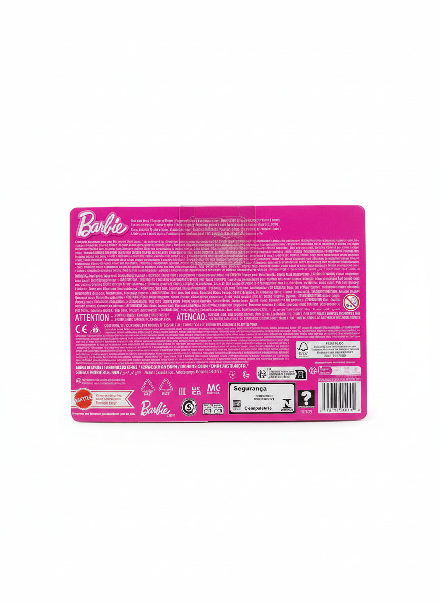 Pink Barbie packaging with text and barcodes on a wooden floor