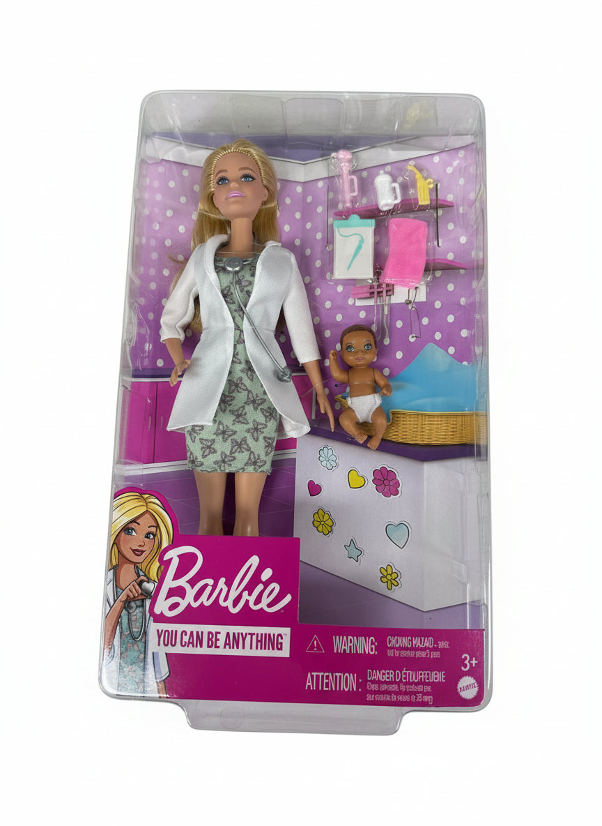 Barbie doll in a doctor's outfit with packaging on a gray surface