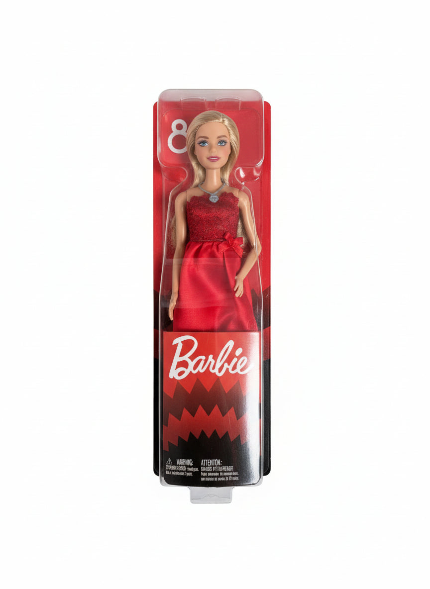Barbie doll in red dress packaging on a chair