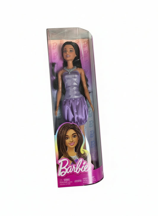 Barbie doll in packaging on a chair
