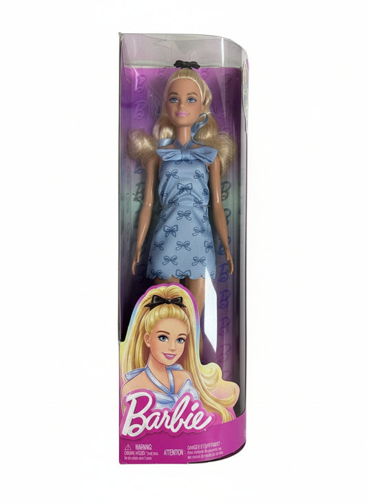 Barbie doll in a blue dress with packaging on a chair
