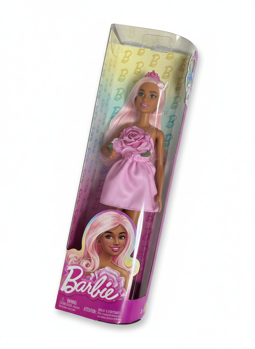 Barbie doll in a pink dress with packaging on a white surface